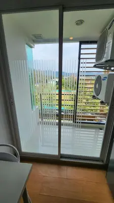 a large window in a room with a view of a balcony at Plus condominium 2 kathu in Kathu
