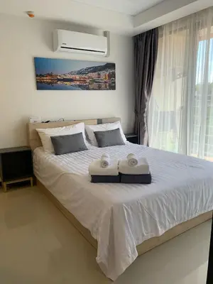 a bedroom with a bed with two towels on it at Nai Harn NBC 1 BR in Rawai Beach