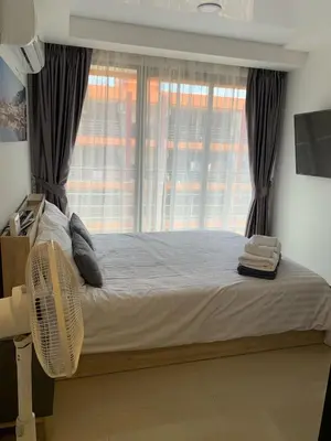 a bedroom with a large bed with a window at Nai Harn NBC 1 BR in Rawai Beach