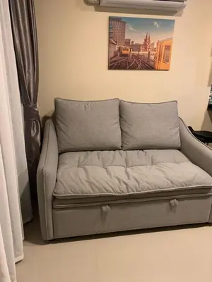 a couch sitting in the corner of a room at Nai Harn NBC 1 BR in Rawai Beach