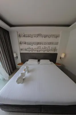 a bed with two stuffed animals sitting on it at The Melody Phuket Kata Beach in Kata Beach