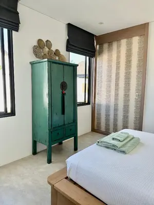 a bedroom with a green cabinet next to a bed at Villa Amata in Phuket Town