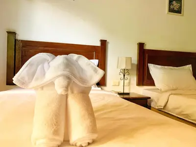 a pile of towels sitting on top of a bed at patong beautiful pool villa in Patong Beach