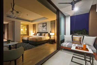 a bedroom with a bed and a living room at 2bdr Lakeview Apartment Angsana oceanview residence by Capital Pro in Bang Tao Beach