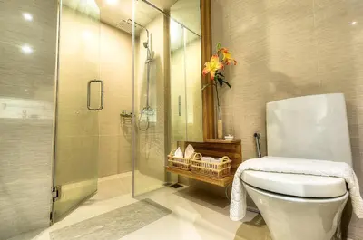 a bathroom with a toilet and a glass shower at The Title Boutique Phuket in Rawai Beach