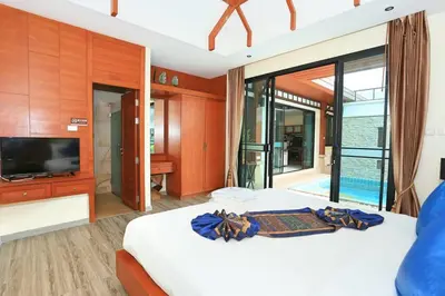 a bedroom with a large bed with a television at Rawai VIP 2D2 Tow-bedroom villa in Phuket Town