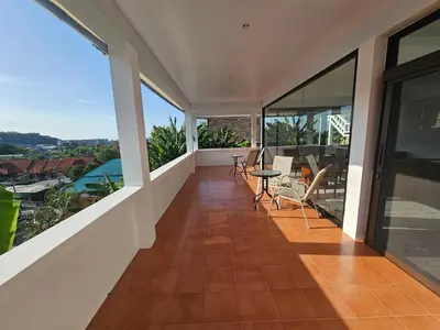 a balcony with a table and chairs on it at Castle Villa Phuket in Kamala Beach