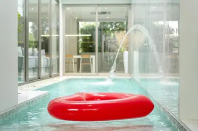 a red float in a pool with a fountain at Aesthetic 3 Storey Villa Residence A23, Private Pool, close to Ma Doo Bua Café and Laguna in Bang Tao Beach