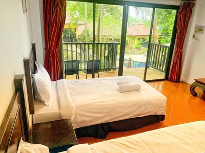 a bedroom with a large bed and a balcony at Charming Pool Twin Holiday Home in Patong Beach