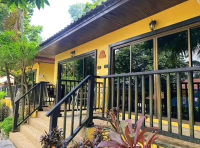 a yellow house with a black railing at Charming Pool Twin Holiday Home in Patong Beach