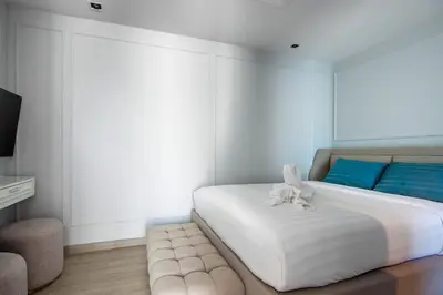 a bedroom with a white bed with a stuffed animal on it at \u3010Beach Front\u3011\u6d77\u666f\u6c99\u6ee9\u522b\u5885\uff0c\u79c1\u4eba\u6cf3\u6c60\uff0c\u514d\u8d39\u65e9\u9910\uff0c\u5973\u4f63\u6bcf\u65e5\u6e05\u6d01\uff0c\u751f\u6d3b\u65b9\u4fbf\u4ea4\u901a\u4fbf\u5229 in Phuket Town