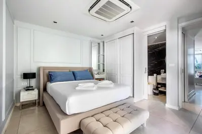 a bedroom with a large white bed with blue pillows at \u3010Beach Front\u3011\u6d77\u666f\u6c99\u6ee9\u522b\u5885\uff0c\u79c1\u4eba\u6cf3\u6c60\uff0c\u514d\u8d39\u65e9\u9910\uff0c\u5973\u4f63\u6bcf\u65e5\u6e05\u6d01\uff0c\u751f\u6d3b\u65b9\u4fbf\u4ea4\u901a\u4fbf\u5229 in Phuket Town