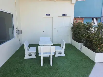 a patio with a table and two chairs on the grass at Angels 