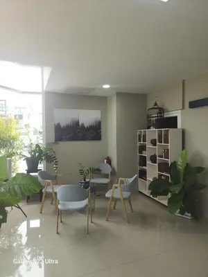 a living room with chairs and tables and plants at Angels 