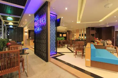 a lobby of a restaurant with a blue bench and tables at The Crystal Beach Hotel in Patong Beach