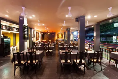 a dining room with tables and chairs in a restaurant at Two Chefs Inn in Kata Beach