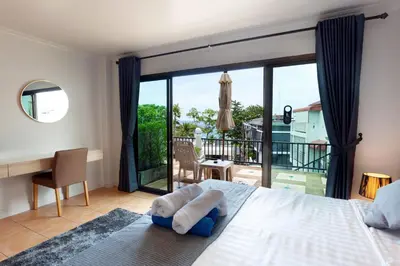 a bedroom with a bed with a view of a balcony at Two Chefs Inn in Kata Beach