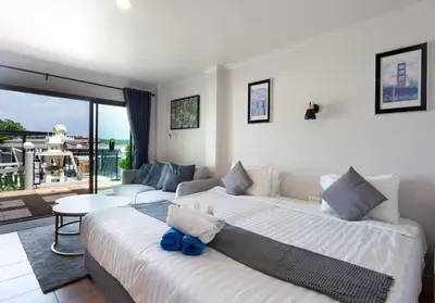 a bedroom with two beds and a living room at Two Chefs Inn in Kata Beach