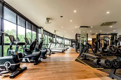 a gym with a row of treadmills and exercise bikes at Citygate Condo Kamala Phuket in Kamala Beach