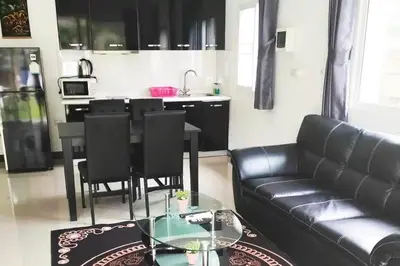 a living room with a black leather couch and a table at 2 Bedrooms Pool Villa in Kamala in Kamala Beach