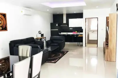 a living room with black furniture and a kitchen at 3 Bedrooms Pool Villa in Kamala in Kamala Beach