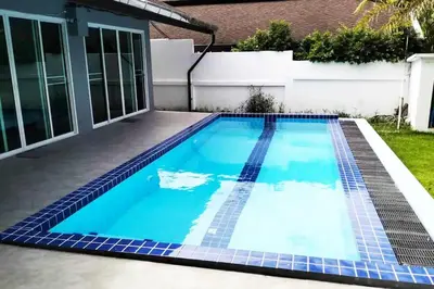 a swimming pool with blue tiles on the floor and a house at 3 Bedrooms Pool Villa in Kamala in Kamala Beach