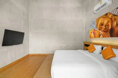 a bedroom with a white bed and a flat screen tv at Canary Villa - Kamala Beach in Kamala Beach
