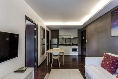 a living room with a white couch and a kitchen at Cozy apartment at The Title Rawai by Lofty in Rawai Beach