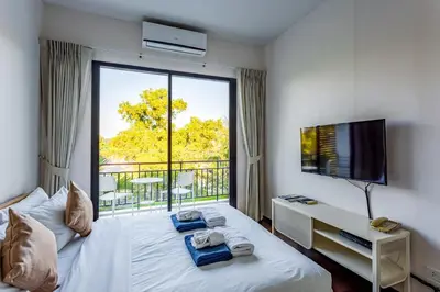 a bedroom with a bed with a window and a tv at Cozy apartment at The Title Rawai by Lofty in Rawai Beach