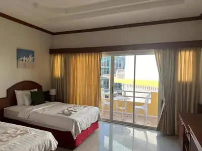 a hotel room with two beds and a balcony at Sabai Sabai hotel in Kata Beach
