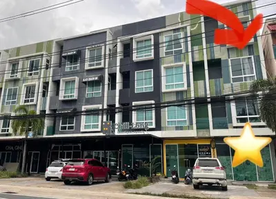 a building with cars parked in front of it at Chalong Inn Phuket in Ban Klang