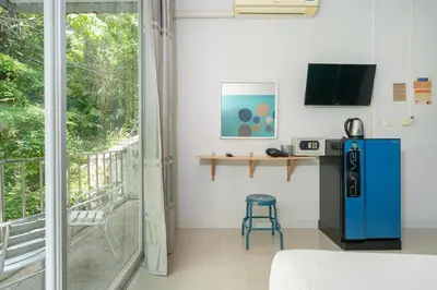 a room with a blue refrigerator and a balcony at Kata Sea Boutique in Kata Beach