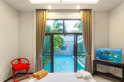 a bedroom with a large window with a view of a pool at Stylish 3BR Pool Villa Onyx H4, Gated Residence, Near Rawai & Naiharn Beach in Rawai Beach
