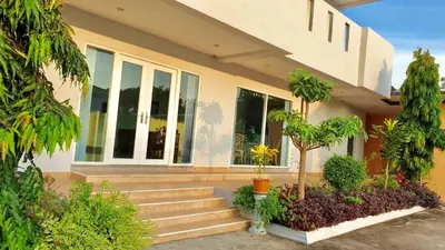 a house with stairs and plants in front of it at Siray House in Phuket Town