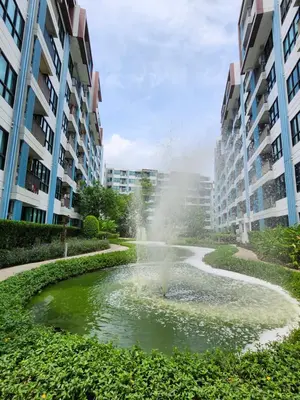 a fountain in a pond in a city with buildings at cen 1 bed room 848 in Ban Rangeng