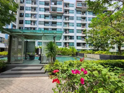 a large apartment building with a swimming pool and flowers at cen 1 bed room 848 in Ban Rangeng