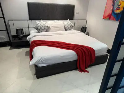 a bedroom with a large bed with a red blanket on it at Kata Beach Luxury Condo - Spacious - Exquisitely Furnished - 6min walk to beach - 2025 Booking Traveller Award Winner in Kata Beach