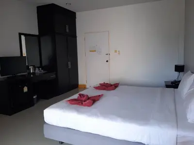 a bedroom with a white bed with red bows on it at Karon Sea Side in Karon Beach