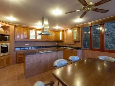 a kitchen with a table and chairs and a ceiling fan at Patonghill estate 6 bedroom sea view in Patong Beach