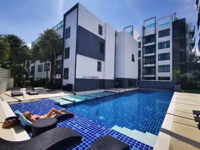 a woman laying on lounge chairs next to a swimming pool at Luxury 2 Bedroom Private Pool Villa in Kamala Walk to Beach Shops and Dining in Kamala Beach
