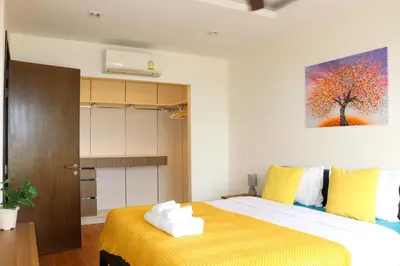 a bedroom with a bed and a painting on the wall at Lovely Townhouse in Laguna Park in Thalang