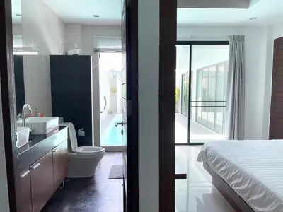 a bathroom with a bed and a sink and a toilet at John’s pool villa Rawai in Ban Saiyuan (1)