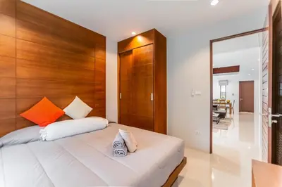 a bedroom with a bed with a wooden headboard at John’s pool villa Rawai in Ban Saiyuan (1)