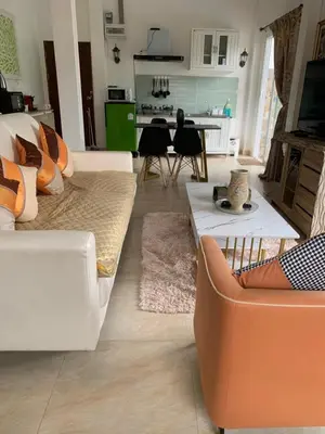 a living room with two couches and a kitchen at Villa du Bonheur Mer et Nature Rawai beach in Phuket Town