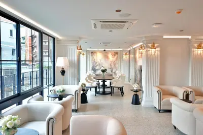 a waiting room with white chairs and a table at Chateau Du Village Patong in Patong Beach