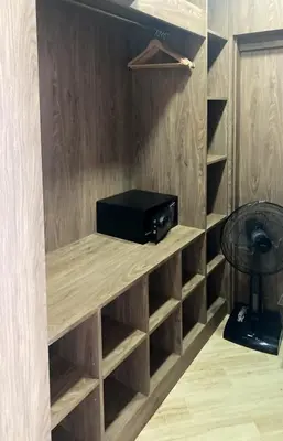 a small black microwave sitting on a shelf in a room at Appartements avec piscine in Rawai Beach