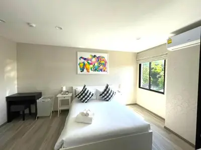 a bedroom with a white bed and a desk in it at B5 НОВАЯ вид БАССЕЙН ВАТСАП669З582I976 in Phuket Town