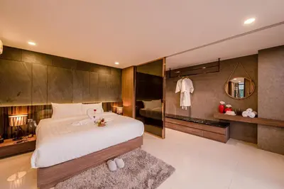 a bedroom with a large white bed and a mirror at Duplex Pool Access 2brs Patong in Patong Beach