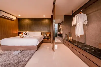 a bedroom with a large bed and a bathroom at Duplex Pool Access 2brs Patong in Patong Beach