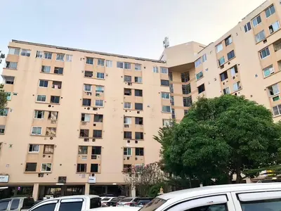 a large apartment building with cars parked in a parking lot at Cozy Patong studio apartment in Patong Beach